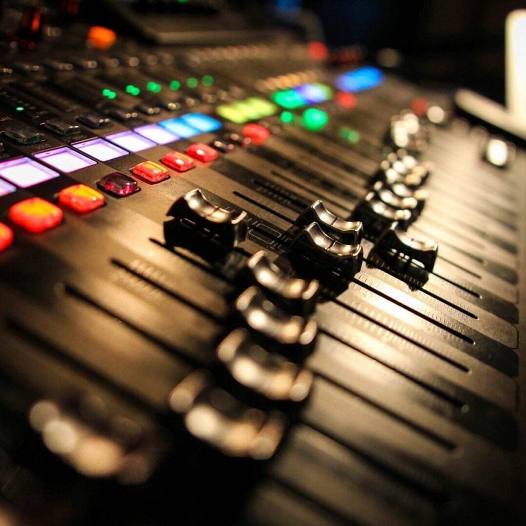 A close up of the knobs on an audio mixing board.